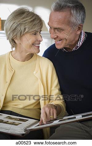 Mature couple looking at photo album View Large Photo Image Stock Image - Mature couple looking at photo album. Fotosearch