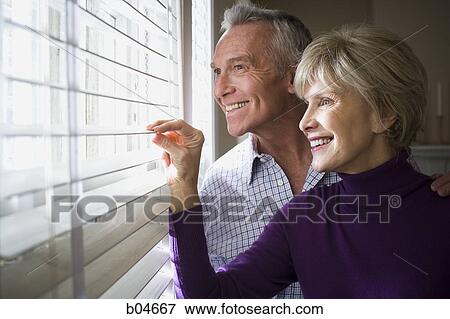 Mature couple looking through blinds View Large Photo Image Stock Photo - Mature couple looking through blinds. Fotosearch