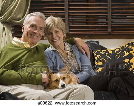 Mature couple on sofa with dog View Large Photo Image Stock Image - Mature couple on sofa with dog. Fotosearch