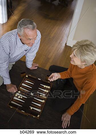 Stock Photo - Mature couple playing backgammon. Fotosearch