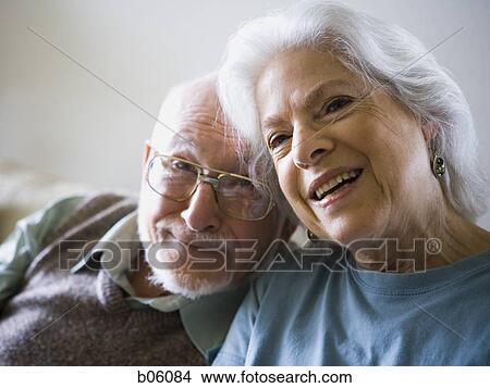 Mature couple sitting on the couch View Large Photo Image Picture - Mature couple sitting on the couch. Fotosearch