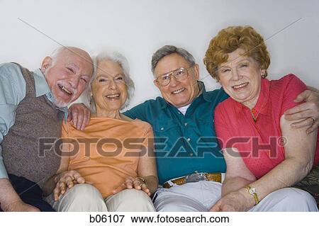 Stock Photo - Mature couples sitting on the couch. Fotosearch