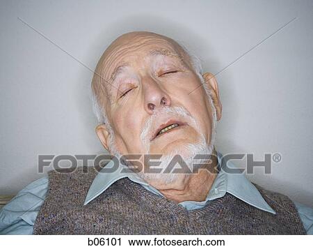 Stock Image - Mature man asleep sitting on a couch. Fotosearch