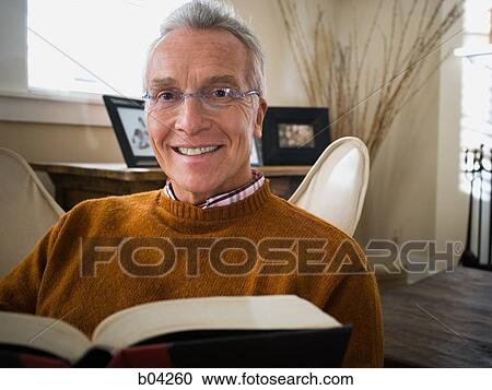 Mature man sitting in chair reading View Large Photo Image Stock Image - Mature man sitting in chair reading. Fotosearch