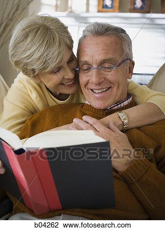 Mature man with book and mature woman hugging him View Large Photo Image Stock Image - Mature man with book and mature woman hugging him. Fotosearch