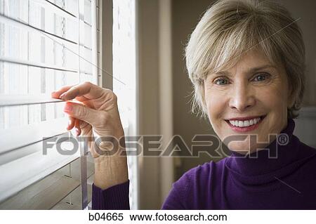Stock Photography - Mature woman at window. Fotosearch