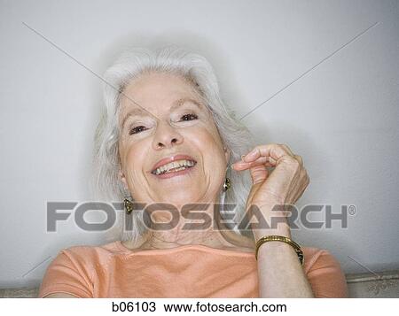 Mature woman sitting on a couch View Large Photo Image Stock Image - Mature woman sitting on a couch. Fotosearch