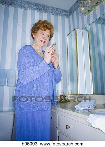 Mature woman smelling perfume View Large Photo Image Stock Image - Mature woman smelling perfume. Fotosearch