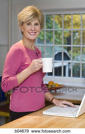 Stock Photo - Mature woman with laptop. Fotosearch