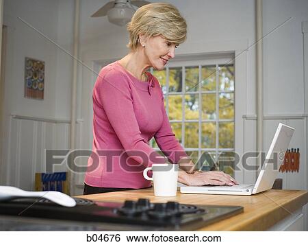 Stock Photograph - Mature woman with laptop. Fotosearch