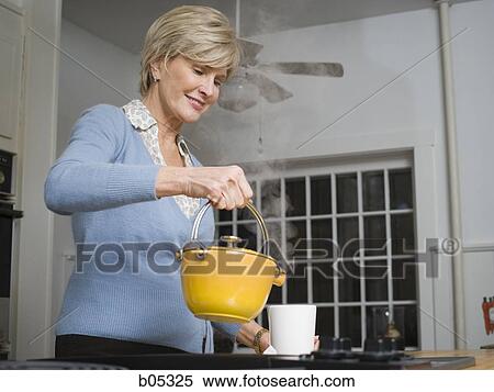 Mature woman with steaming kettle in kitchen View Large Photo Image Stock Photography - Mature woman with steaming kettle in kitchen. Fotosearch