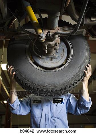 Mechanic fixing car tire View Large Photo Image Stock Image - Mechanic fixing car tire. Fotosearch