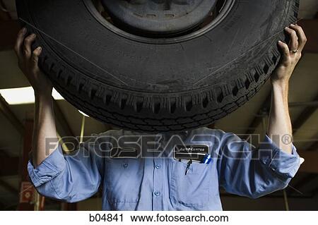 Mechanic fixing tire View Large Photo Image Stock Image - Mechanic fixing tire. Fotosearch