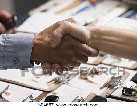 Mechanic shaking Hands over clipboards View Large Photo Image Stock Photo - Mechanic shaking Hands over clipboards. Fotosearch