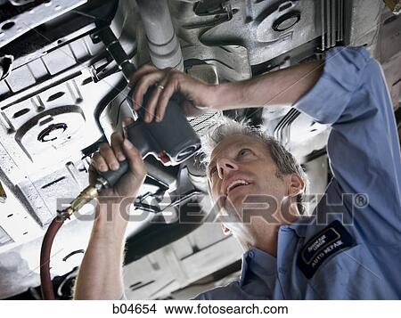 Mechanic working on car View Large Photo Image Picture - Mechanic working on car. Fotosearch