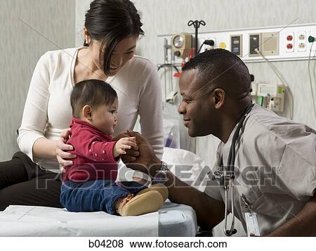 Mother and baby in examining room with doctor View Large Photo Image Stock Photo - Mother and baby in examining room with doctor. Fotosearch