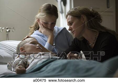 Mother and sister sitting by young boy in hospital bed View Large Photo Image Stock Photography - Mother and sister sitting by young boy in hospital bed. Fotosearch