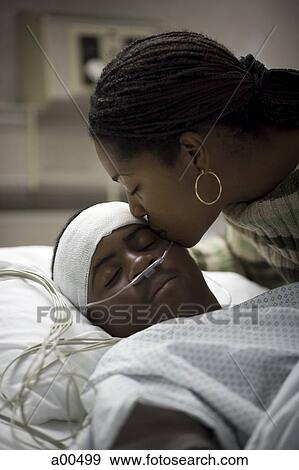 Mother kissing her son in hospital bed View Large Photo Image Stock Photo - Mother kissing her son in hospital bed. Fotosearch