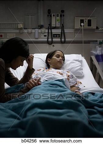Mother sitting by daughter in hospital bed View Large Photo Image Stock Photograph - Mother sitting by daughter in hospital bed. Fotosearch