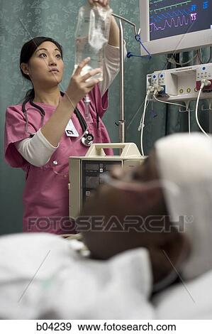 Nurse adjusting IV bag for patient View Large Photo Image Stock Photo - Nurse adjusting IV bag for patient. Fotosearch