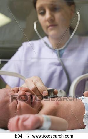 Nurse examining crying newborn in incubator View Large Photo Image Stock Photo - Nurse examining crying newborn in incubator. Fotosearch