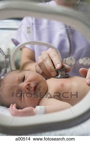 Nurse examining newborn in incubator View Large Photo Image Picture - Nurse examining newborn in incubator. Fotosearch