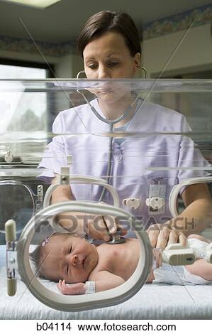 Nurse examining newborn in incubator View Large Photo Image Picture - Nurse examining newborn in incubator. Fotosearch