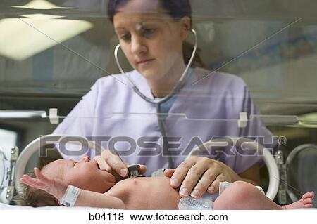 Nurse examining newborn in incubator View Large Photo Image Stock Photo - Nurse examining newborn in incubator. Fotosearch