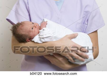 Nurse holding newborn baby View Large Photo Image Stock Image - Nurse holding newborn baby. Fotosearch