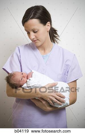 Nurse holding newborn baby View Large Photo Image Stock Photo - Nurse holding newborn baby. Fotosearch