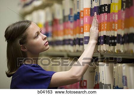 Nurse looking through patient records View Large Photo Image Stock Image - Nurse looking through patient records. Fotosearch