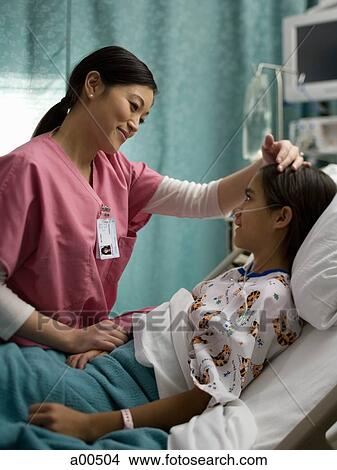 Nurse talking to girl in hospital bed View Large Photo Image Picture - Nurse talking to girl in hospital bed. Fotosearch