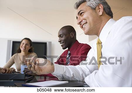 Stock Photo - Older Businessman talking at meeting. Fotosearch