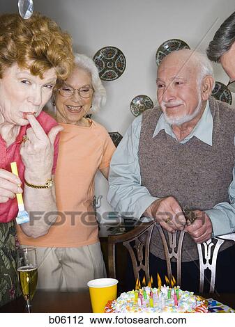 Partygoers around a birthday cake View Large Photo Image Stock Image - Partygoers around a birthday cake. Fotosearch
