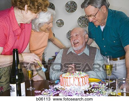 Partygoers around a birthday cake View Large Photo Image Stock Image - Partygoers around a birthday cake. Fotosearch