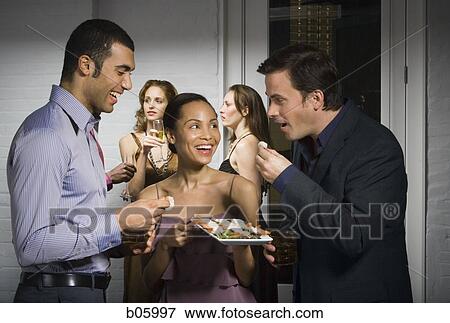 Stock Photo - Partygoers eating. Fotosearch