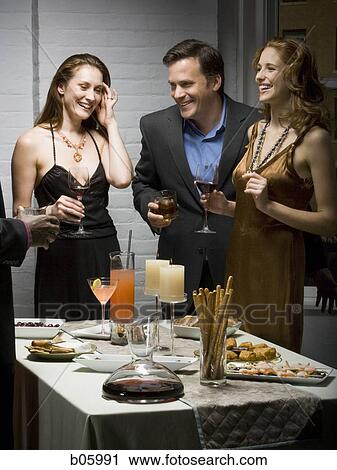 Stock Image - Partygoers socializing. Fotosearch