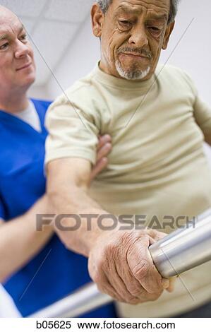 Physical Therapist holding a patient while walking View Large Photo Image Stock Photography - Physical Therapist holding a patient while walking. Fotosearch