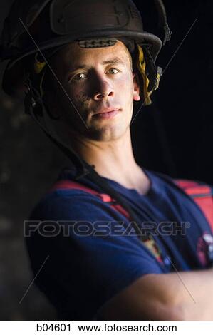 Stock Image - Portrait of a firefighter with arms crossed. Fotosearch