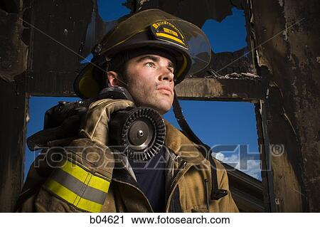 Stock Image - Portrait of a firefighter with fire hose. Fotosearch