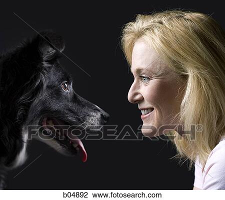 Portrait of a woman facing black dog smiling View Large Photo Image Stock Image - Portrait of a woman facing black dog smiling. Fotosearch