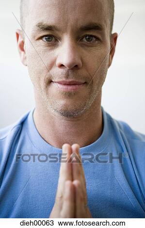 Stock Image - Portrait of man with hands together. Fotosearch