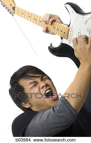 Portrait of young man playing electric guitar View Large Photo Image Picture - Portrait of young man playing electric guitar. Fotosearch