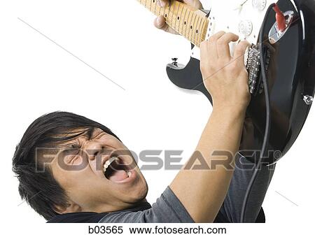 Portrait of young man playing electric guitar View Large Photo Image Stock Photography - Portrait of young man playing electric guitar. Fotosearch