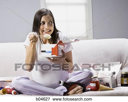 Stock Photo - Pregnant woman eating ice cream. Fotosearch