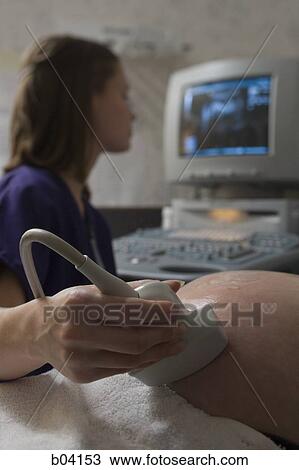 Stock Image - Pregnant woman having an ultrasound. Fotosearch