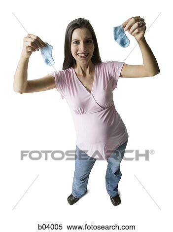 Stock Photography - Pregnant woman holding baby socks. Fotosearch