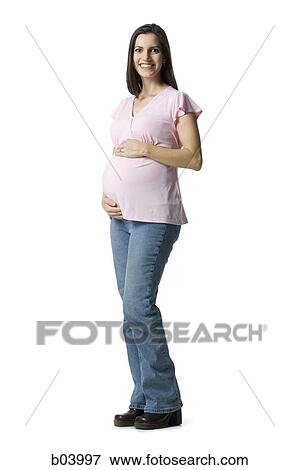 Stock Photo - Pregnant woman holding belly and smiling. Fotosearch