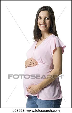 Pregnant woman holding belly and smiling View Large Photo Image Stock Photo - Pregnant woman holding belly and smiling. Fotosearch
