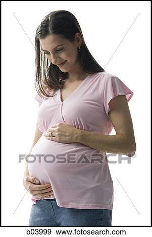 Pregnant woman holding belly and smiling View Large Photo Image Stock Photo - Pregnant woman holding belly and smiling. Fotosearch